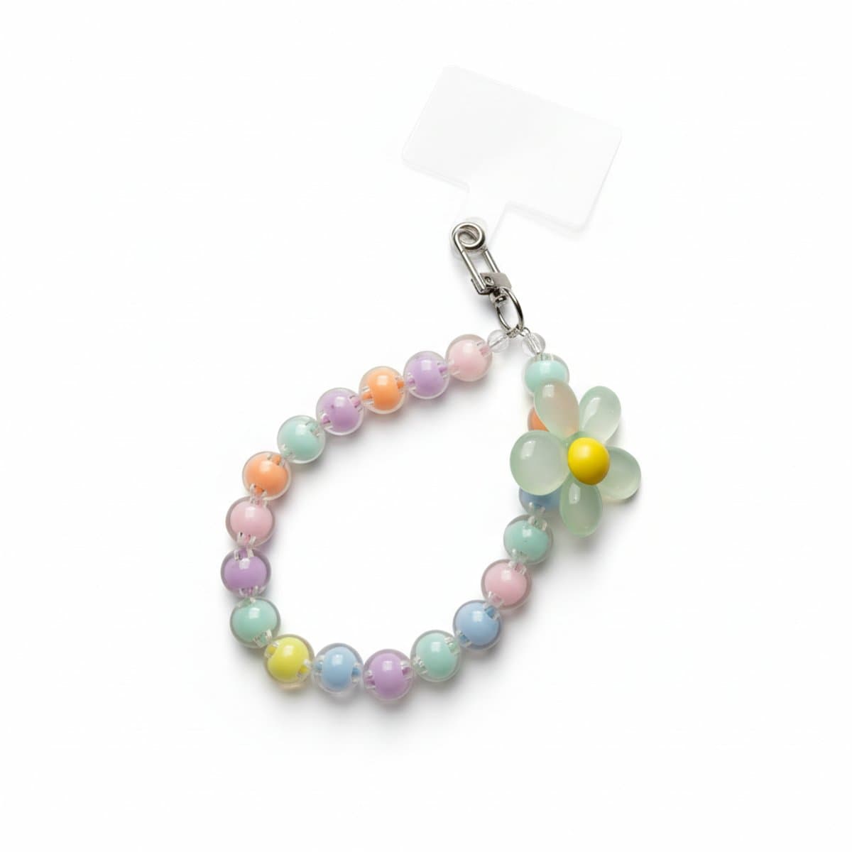 A colorful Y2K style beaded phone charm with pastel translucent beads and a prominent daisy flower, resting on a white wooden surface, available at handpicked306 boutique in Carlyle SK.