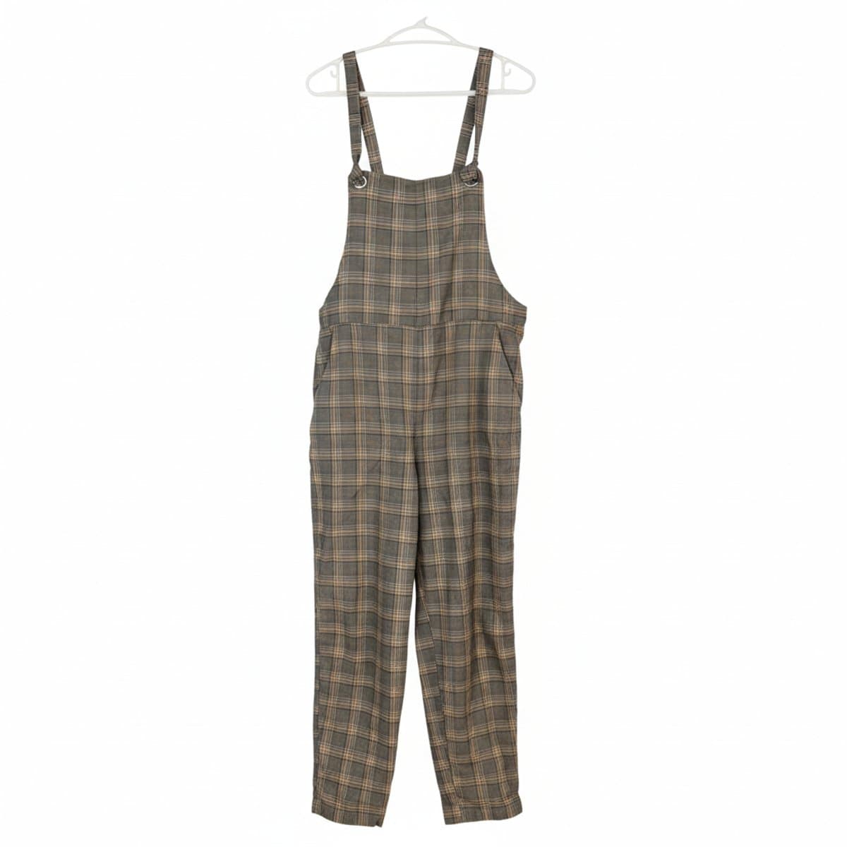 Women's vintage-inspired plaid overalls with a tapered leg, classic brown and grey check pattern, hanging in a curated boutique setting at handpicked306.