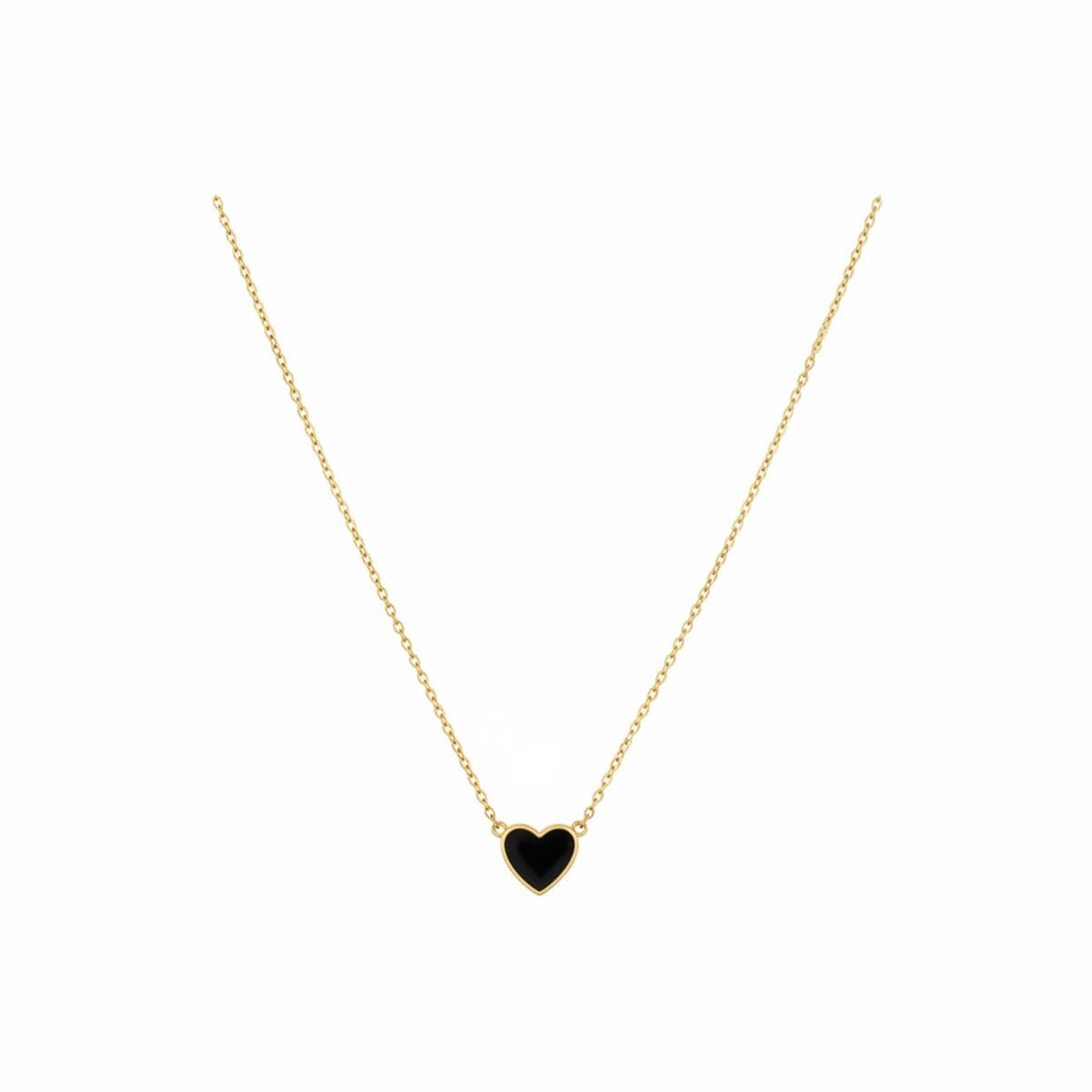 A delicate gold-tone necklace featuring a small black enamel heart pendant, laid flat on a rustic white wood background, available at handpicked306 boutique in Carlyle SK.